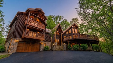 Grand log cabin exterior surrounded by trees, setting the scene for a spacious mountain retreat and unforgettable group vacation