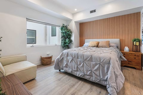 Relax in this stylish bedroom featuring a unique wood slat accent wall. A large window make this a peaceful spot to recharge after a day of exploring.