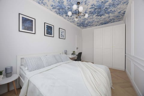 Another bedroom angle showing twin beds, a desk, and framed artwork on the wall. The setup is practical for guests or shared stays.