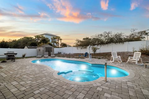 Your private pool glows under painted sunset skies, surrounded by comfortable loungers for evening relaxation.