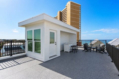 Expansive rooftop terrace features modern cabin structure with panoramic ocean views and comfortable outdoor seating area.