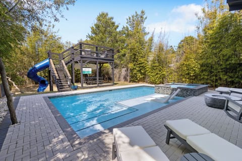 Dive into your private oasis with a sparkling pool, thrilling slide, and cozy hot tub surrounded by mature trees.