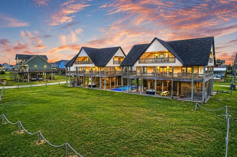 Luxury beachfront beach houses in Crystal Beach TX with elevated design, expansive balconies, private hot tubs, pickleball court and direct Gulf-facing views at sunset.