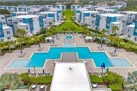 Modern community pool area surrounded by contemporary townhomes and green spaces.
