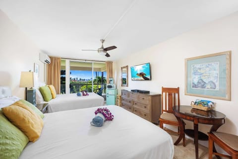 The unit features two queen-size beds, a 42" Samsung TV, split air-conditioning and a ceiling fan, a dresser and nightstand, direct access to a bathroom with a walk-in shower, and private lanai (balcony) access.