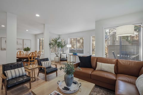 Settle into your bright, modern living space with leather seating and natural light streaming through large windows.