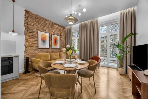 Bright Living Room with Dining Area, Balcony Access and Stylish Brick Wall Design | Book Now with RENTUJEMY.COM