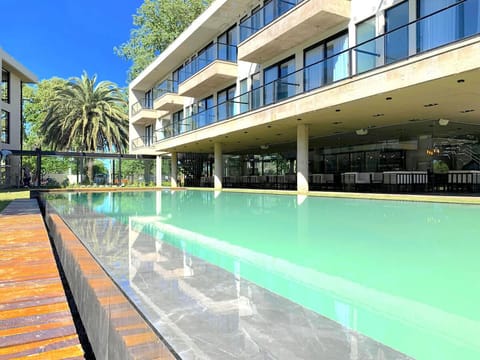 Dive into a sleek pool with resort-style lounging.