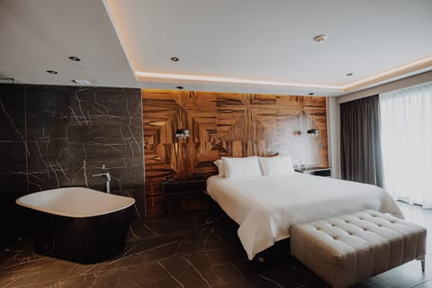 Sink into plush linens beside a spa-style soaking tub.