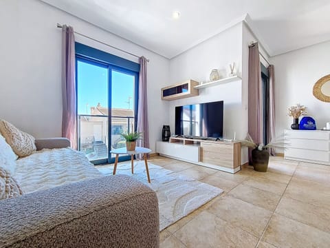 Bright and modern living space in a centrally located 2-bedroom apartment in San Pedro del Pinatar, featuring a cosy lounge, dining area, and access to a private patio.