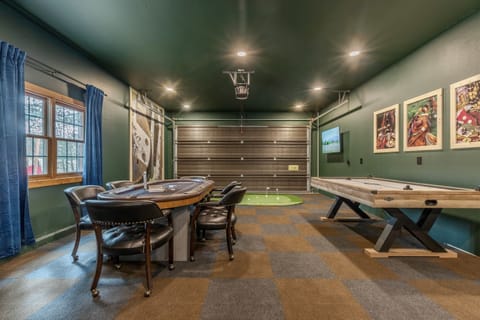 Check out this garage made game room.  Equipped with air hockey, 6-person poker table, putting green, arcade games, dartboard, foose ball and two smart TVs.
