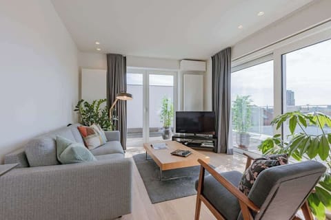Modern living room with large windows and access to a private balcony.