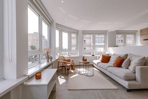 Bright living room with large windows and modern seating for relaxing.