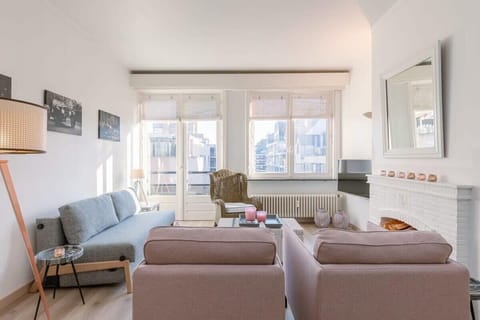 Bright living room with modern seating and large windows overlooking the city.