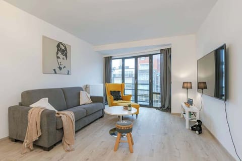 Modern living room with large windows and a bright yellow accent chair