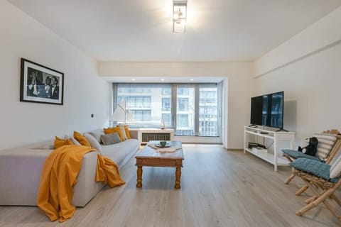 Bright living room with a large sofa and natural light from floor-to-ceiling windows