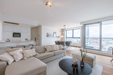 Modern open-concept living area with large windows offering city views
