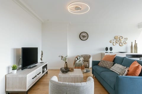 Modern living room with a blue sofa and contemporary lighting fixture