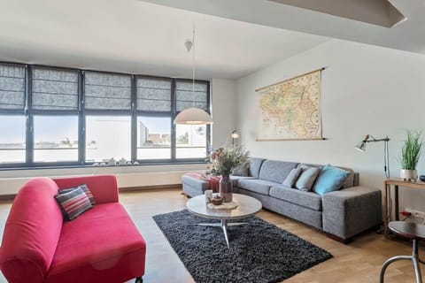 Modern living room with large windows and contrasting sofas for a comfortable stay.
