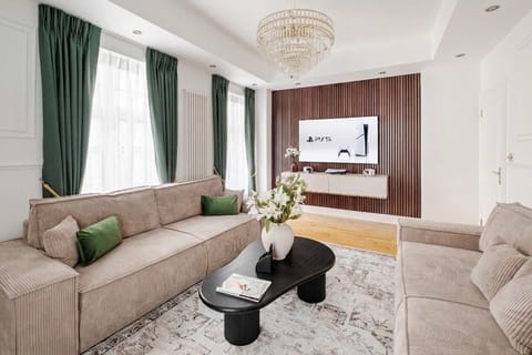 Living room | A bright, stylish living room with two large sofas that convert into comfortable sofa beds. Enjoy a premium 75 inch OLED TV with PS5 for entertainment, all set within a modern space filled with natural light and a warm atmosphere.
