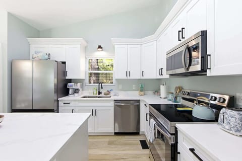 Fully equipped modern kitchen with quartz counters, natural light, and sleek finishes