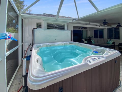 Relax in the private hot tub under a screened enclosure, perfect for unwinding after a day of adventure.