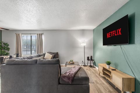 Spacious and inviting living area with comfortable seating and a smart TV, perfect for relaxing after exploring Arlington or attending events at AT&T Stadium.
