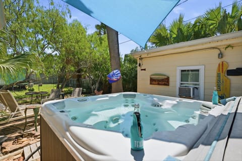 Hot Tub — Shaded Spa with Gone Surfing & Landshark Signs