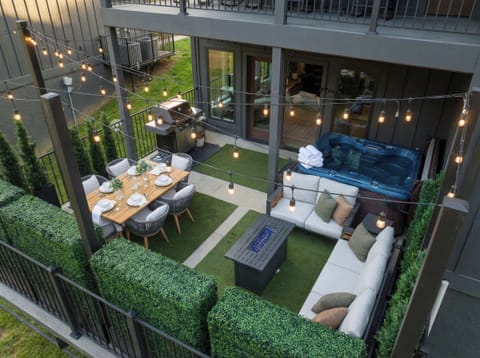 Private courtyard patio w/ lounge seating, dining space & string lights for cozy evenings outdoors