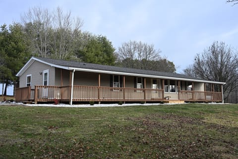 Front/Side view of cabin with porch, perfect for enjoying peaceful evenings and experiencing the tranquility of nature. The inviting porch is ideal for unwinding after a day of exploration, of