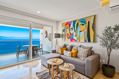 Bright coastal living space with floor-to-ceiling ocean views, designer décor, and seamless access to a private balcony perfect for sunset dining and relaxing by the sea.