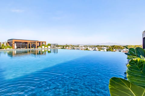 Look across the shimmering blue waters of the infinity pool to take in the expansive city views stretching out to the horizon.