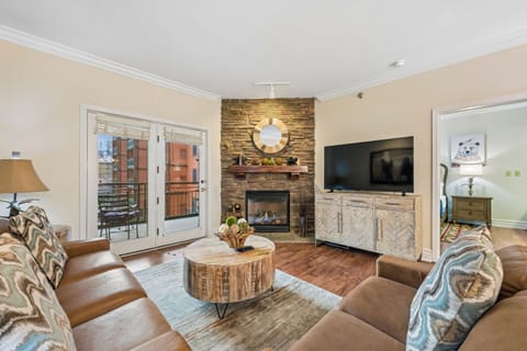Cozy up in your beautifully appointed living room, where rustic stone fireplace meets modern comfort for perfect mountain evenings.
