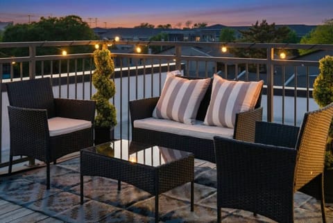 Take in the beautiful sunset views from your private outdoor terrace, complete with a comfortable wicker chat set and ambient string lights