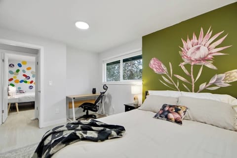 Queen bedroom with floral accent wall and dedicated workspace