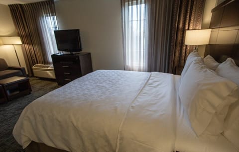 Sink into the plush queen bed, surrounded by warm lighting and inviting decor for a restful night's sleep.