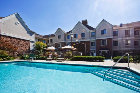 Pool deck with sun loungers and umbrellas — the whirlpool is tucked in the corner