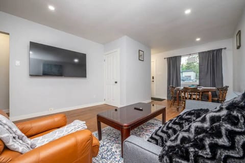 Bright and cozy living room with smart TV, comfortable seating, and plenty of natural light