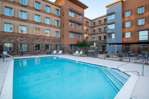 Outdoor pool with gray lounge chairs along the tiled deck