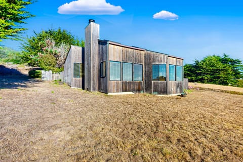 Experience the charm of Clemons' Cottage from the outside, featuring a unique design that blends seamlessly with the beautiful coastal landscape.