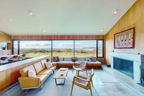 Gaze out at the ocean while lounging in style; this spacious living room invites you to unwind with a cozy wood-burning fireplace.