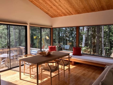 Dine surrounded by nature, with sunlight streaming through expansive windows and the tranquil sounds of the forest just outside.