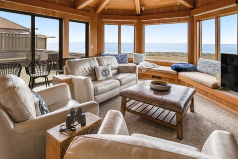 Gather around the wood-burning fireplace in this inviting living room, where panoramic ocean views set the stage for unforgettable moments.