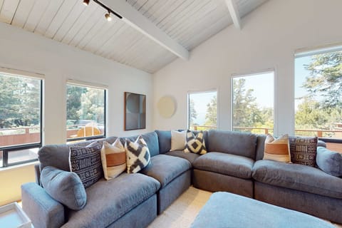Curl up in the cozy corner of the living room, where plush seating and views of the trees create an inviting space for relaxation.