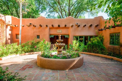 Step into the brick courtyard where a tiled fountain bubbles among the gardens