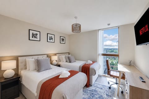 Modern bedroom with twin zip and link beds (setup as singles by default and can be setup as superking on advanced notice). A desk and chair are also offered for those who need to work from home.