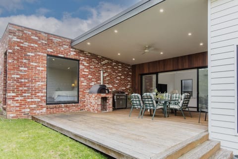 The alfresco from outside — exposed brick, pizza oven, and a covered dining area all in one spot.