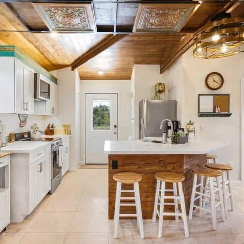 Bright, open-concept kitchen with soaring wood-beamed ceilings, stylish Southwestern details, and modern appliances. The spacious island with bar seating is perfect for morning coffee or casual meals.
