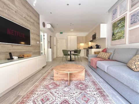 Living area equipped with a sofa bed, a flat-screen Cable TV for entertainment and a balcony.