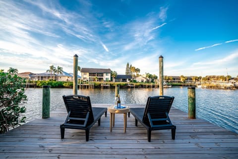 Unwind on your private waterfront deck with comfortable loungers overlooking the tranquil canal and charming neighborhood homes.